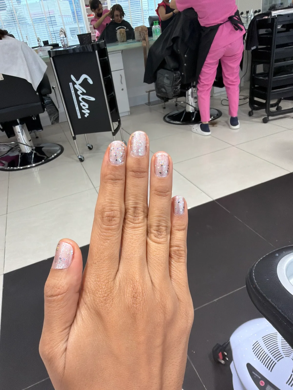 Glitter manicure photographed inside the salon