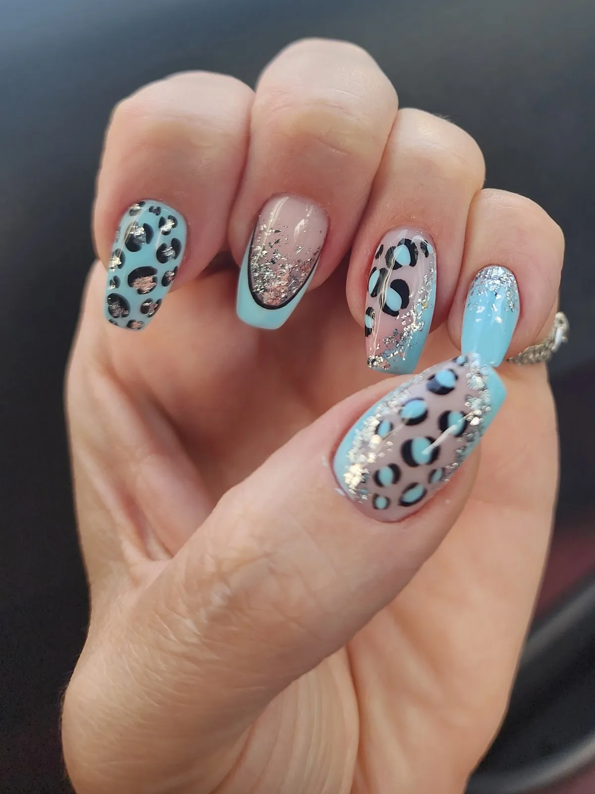 Blue leopard-print nail art with glitter accents