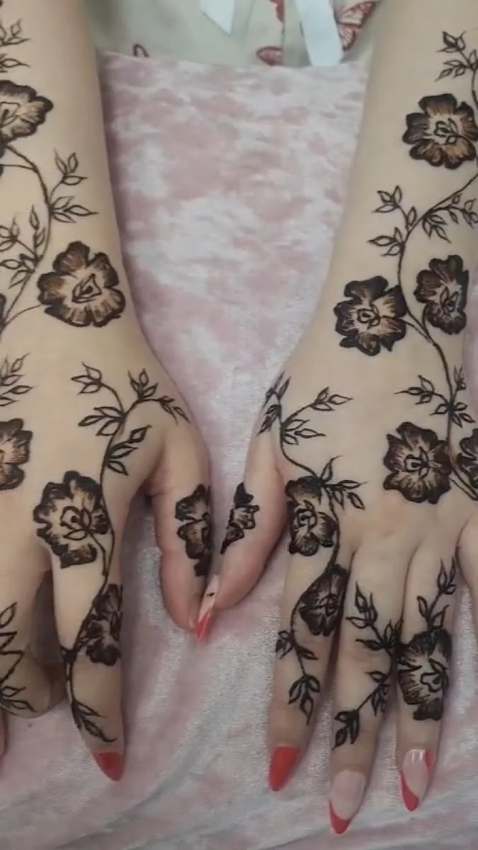 Detailed floral henna and mehndi across a client's hands at Falak Ladies Salon