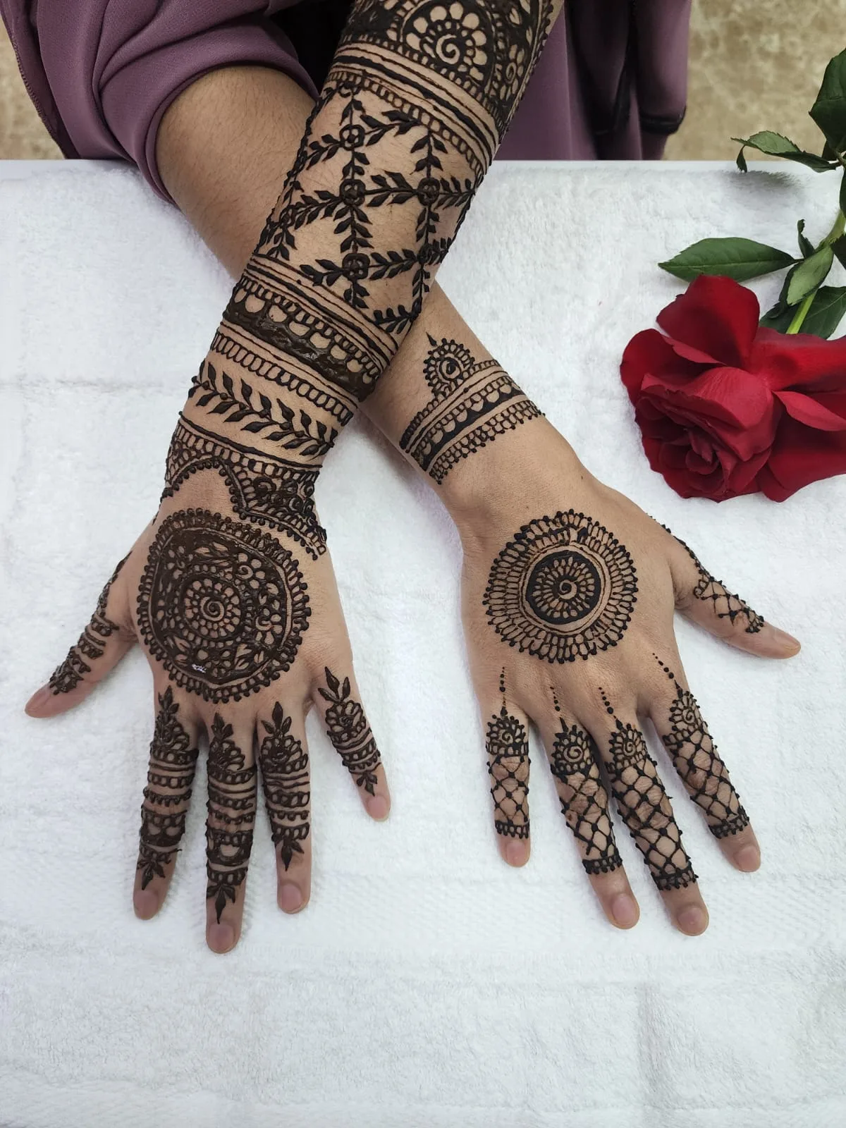 Detailed bridal henna design covering hands and forearms