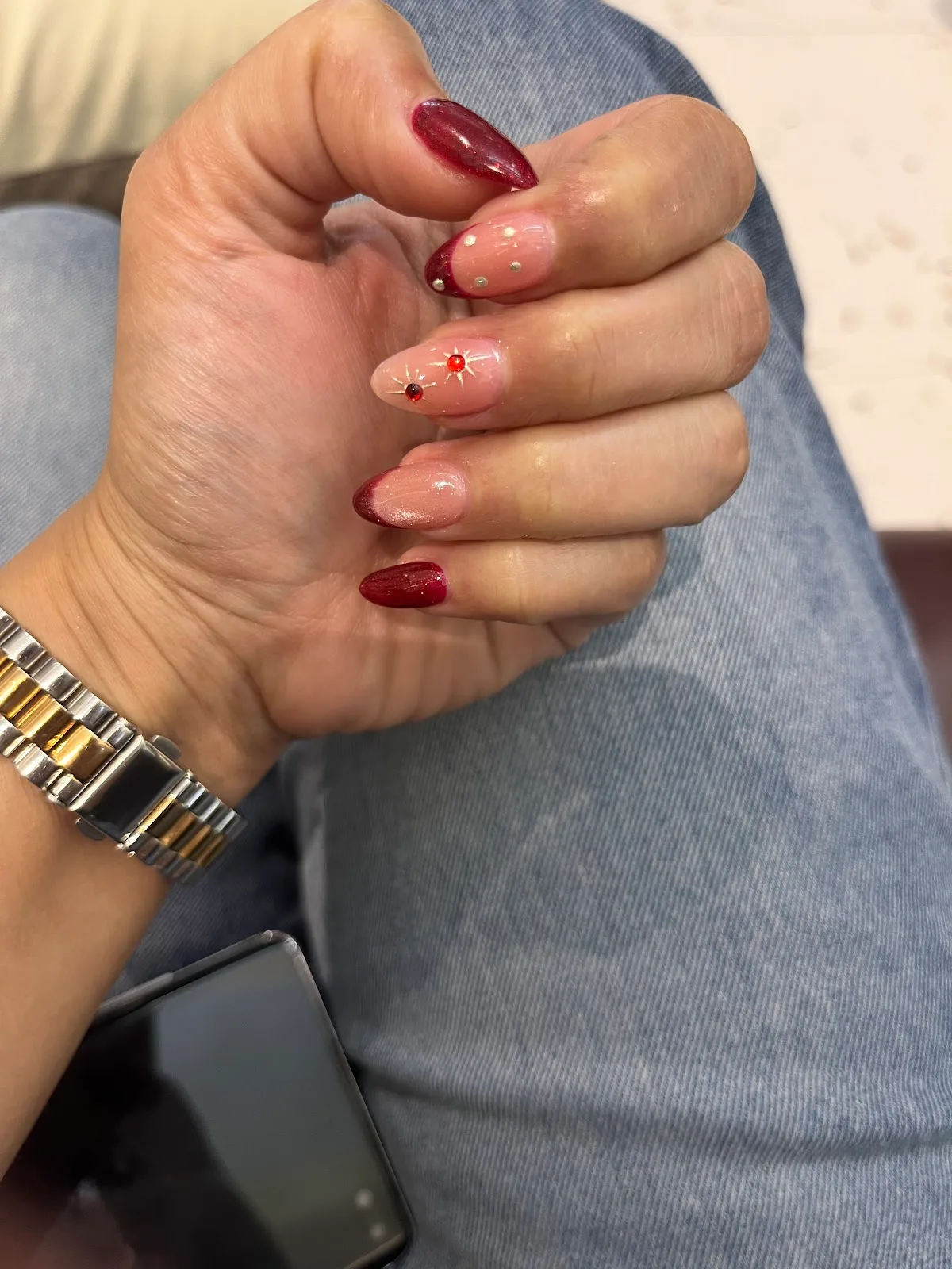 Deep red almond nails with crystal accents