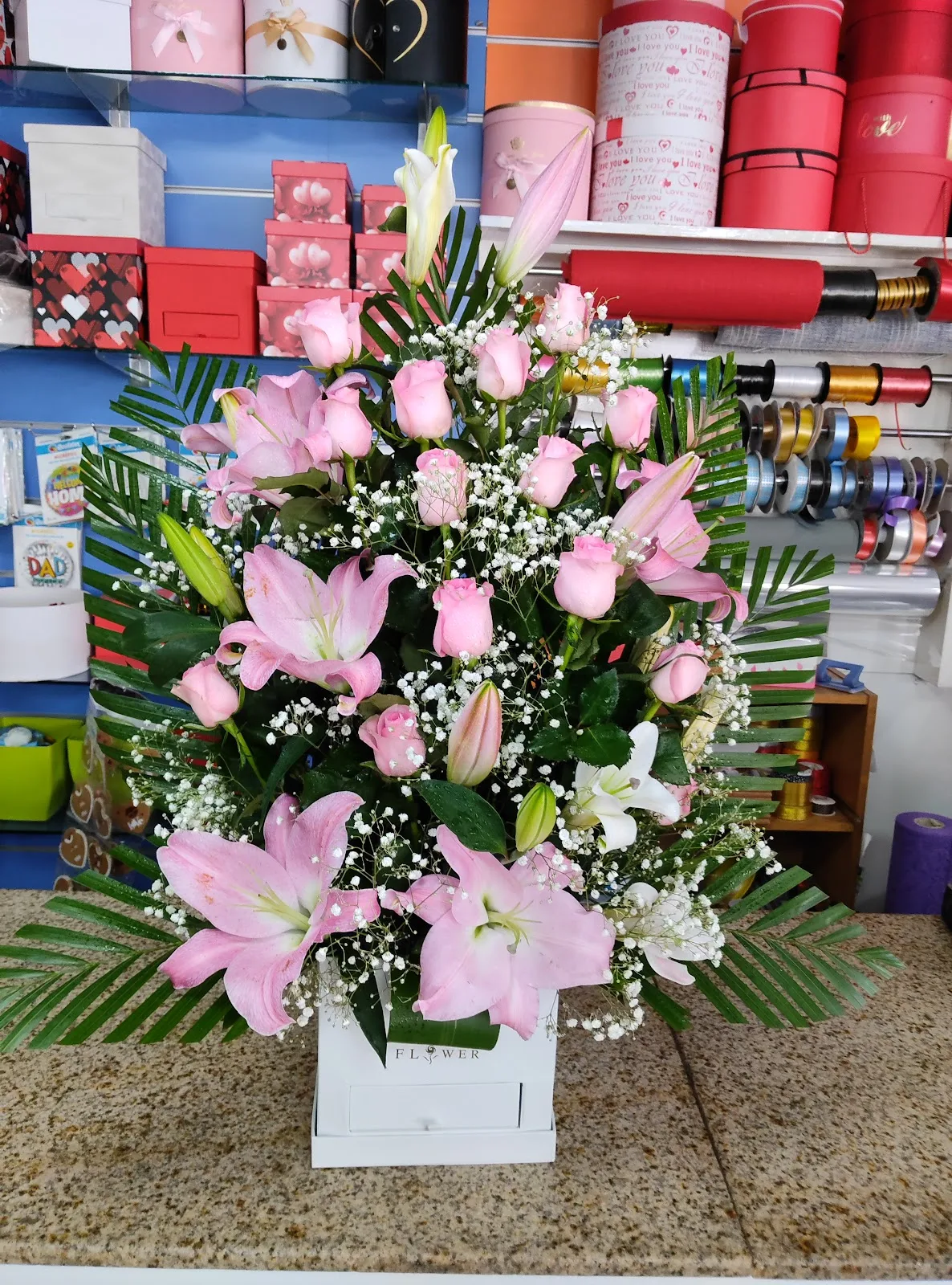 Pink lily and rose arrangement in a flower box