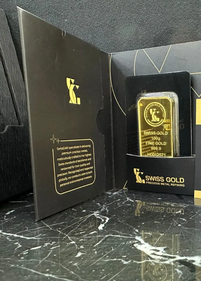 Boxed 100g Swiss Gold fine gold bar presented on dark marble