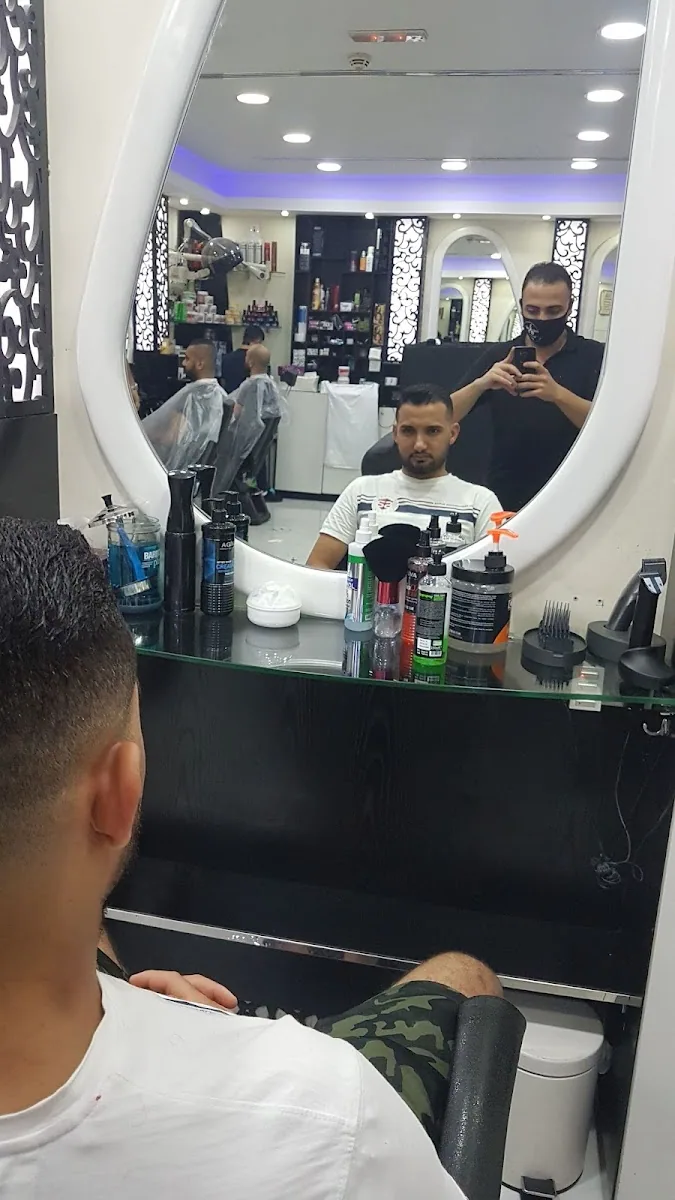 Client in the barber chair facing the salon's oval mirror