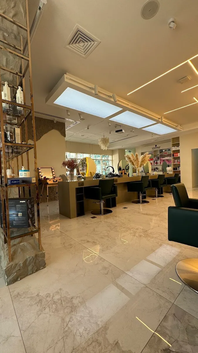 Wide view of JM Beauty Salon interior with marble floors and brass detailing