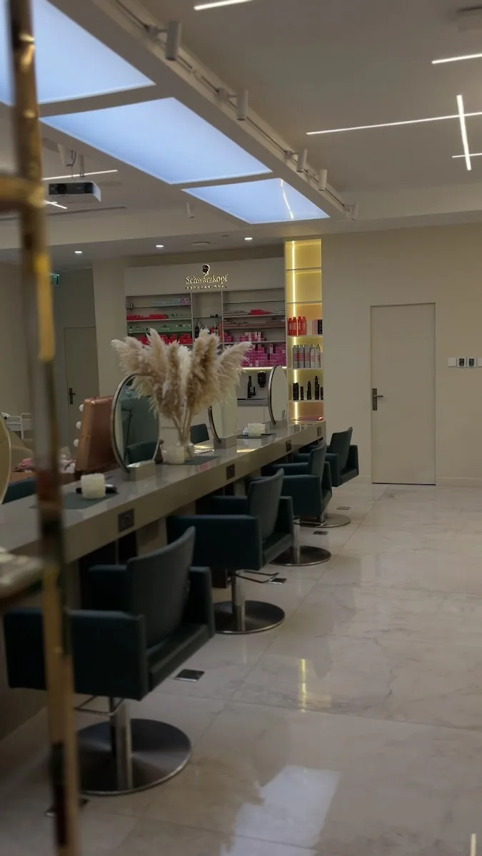 Styling stations with brass mirrors, pampas grass and emerald chairs inside JM Beauty Salon
