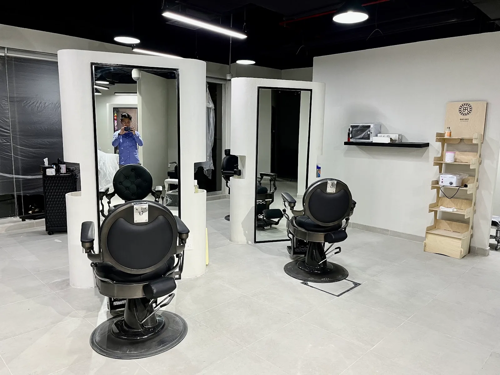 Interior of FIX8 Gents Salon showing two black barber chairs and curved white mirror stations