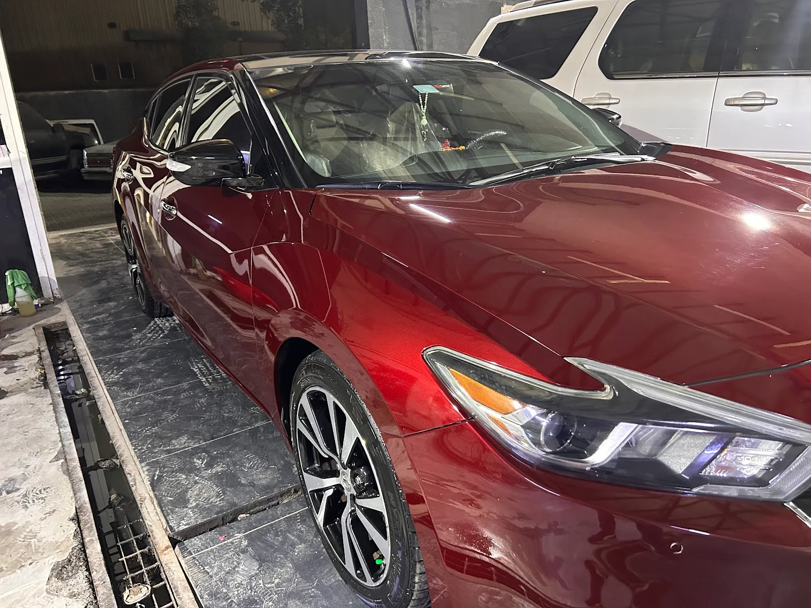 Deep candy-red sedan with a flawless mirror-gloss finish after polishing at H&M Car Polishing