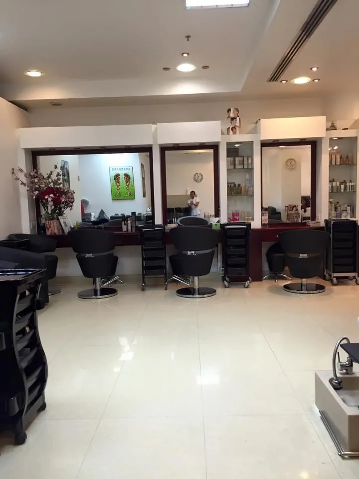 A row of mirrored styling stations with product shelves