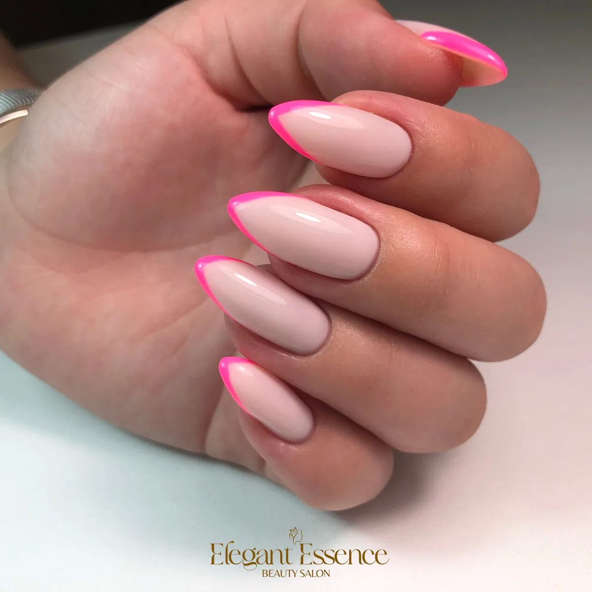 Almond nails with neon-pink French tips by Elegant Essence