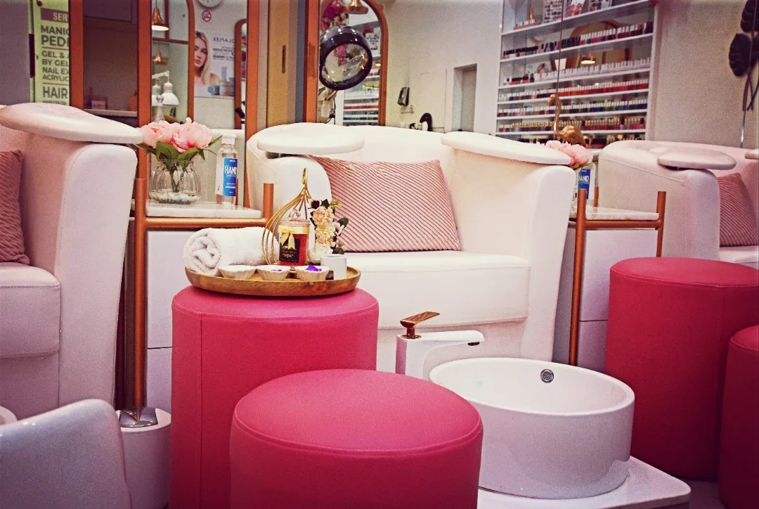 Pedicure lounge with comfortable seating and flowers