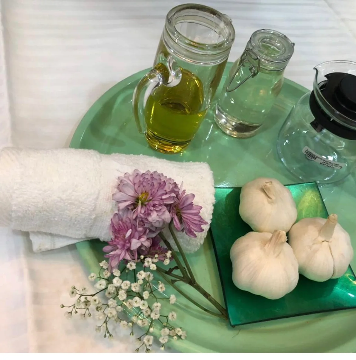 Spa tray with folded towel, fresh flowers and natural oils