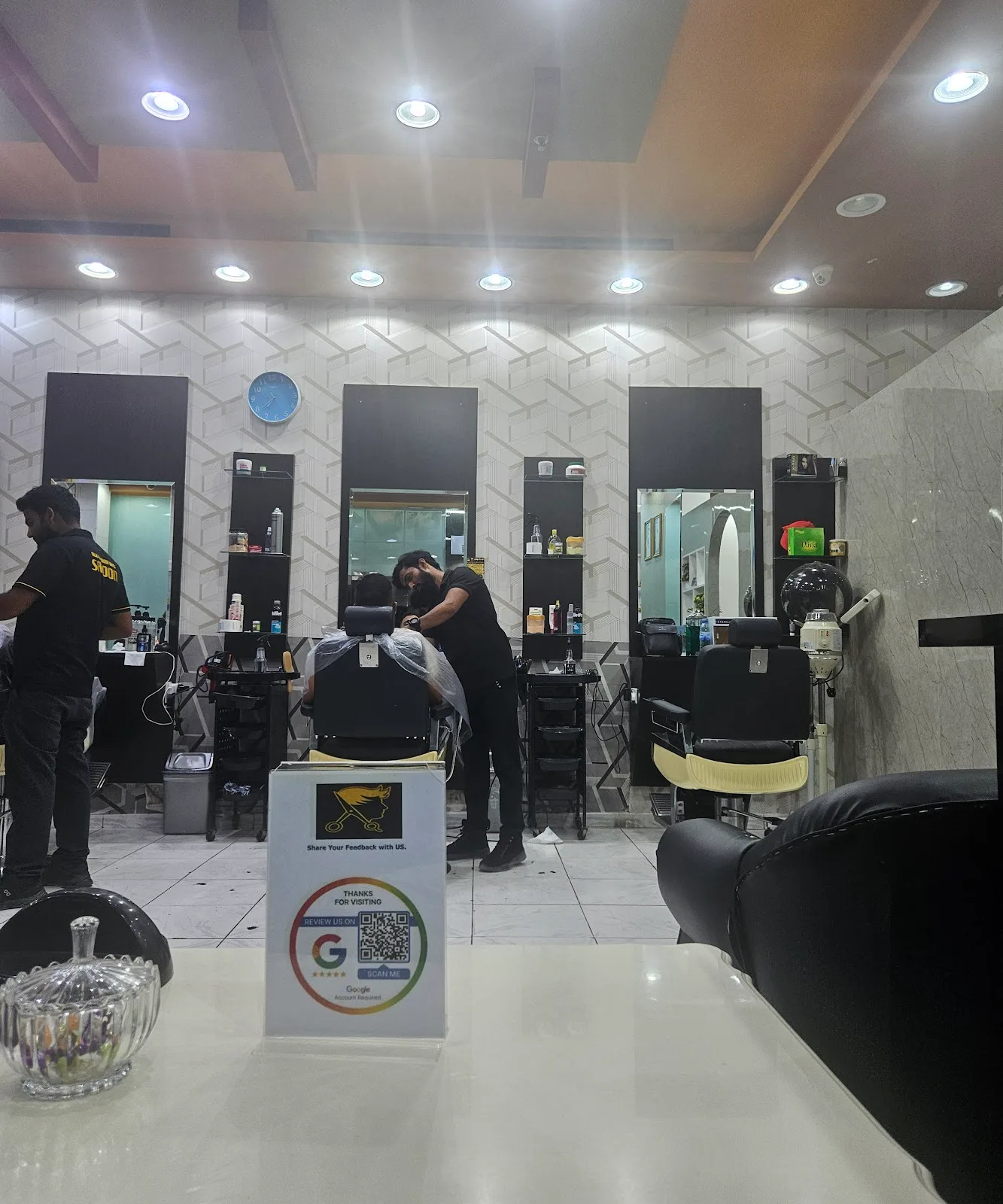 Inside Falak Al Mashoor Gents Salon — barbers working at the mirror stations