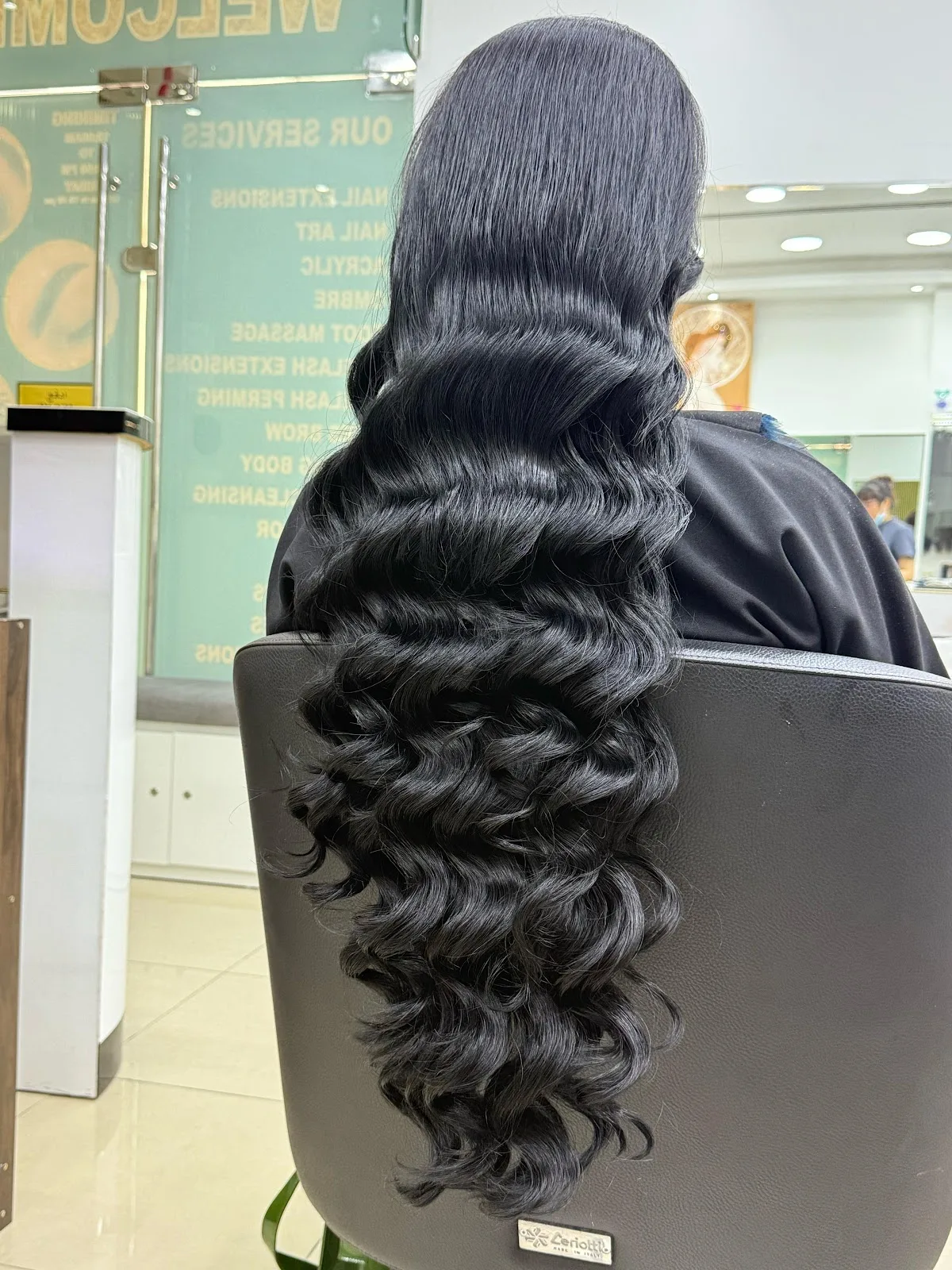 Long glossy black hair styled into soft Hollywood waves at Huyen Nguyen Beauty Salon