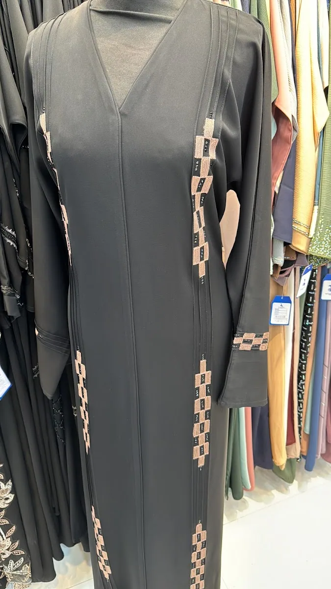 Black abaya with vertical beaded panels on display
