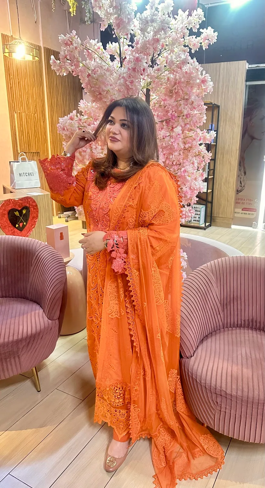Guest in the bright cherry-blossom lounge corner at D Meraki Beauty Lounge