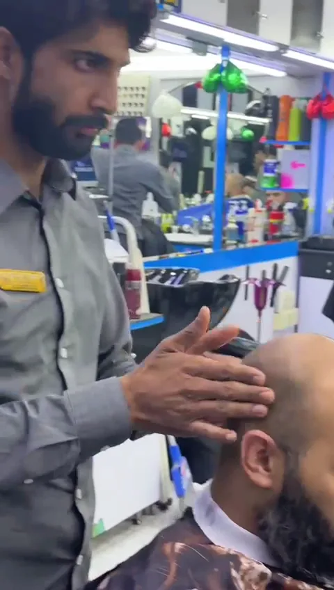 A barber giving a client a head and scalp massage