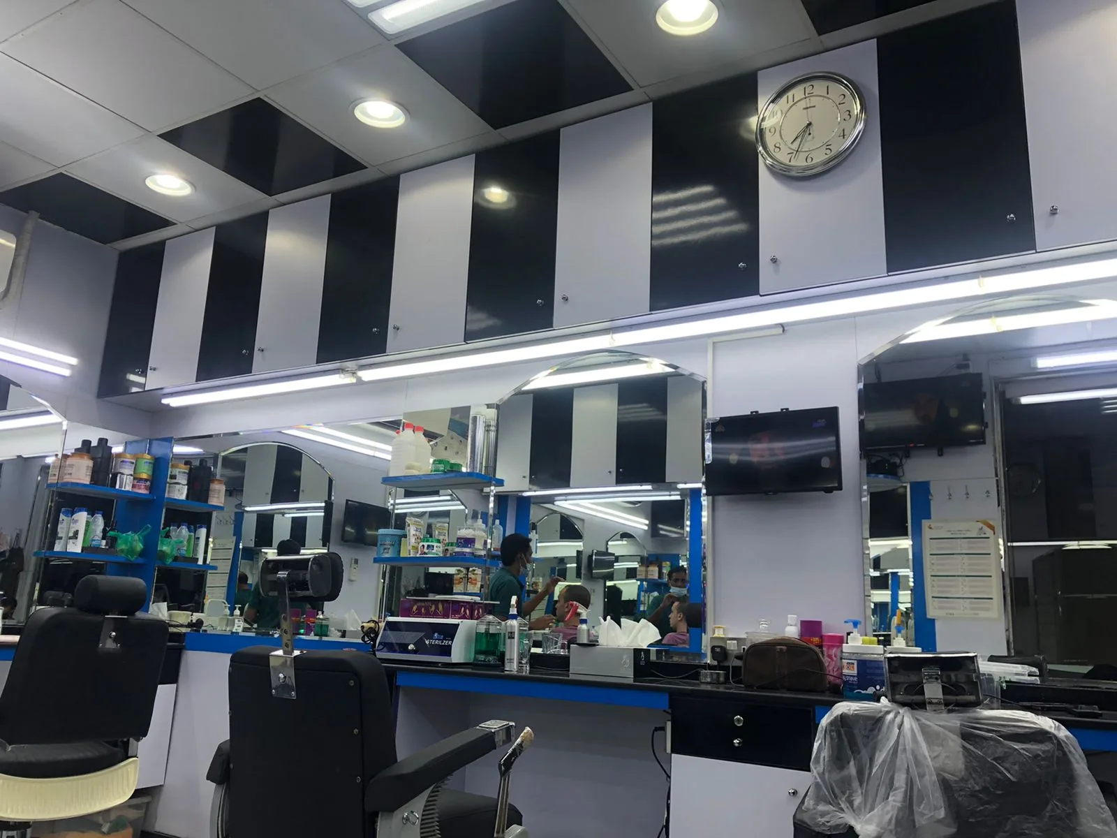 Interior of Yathreeb Gents Salon with black-and-white panelled walls, mirrors and barber chairs