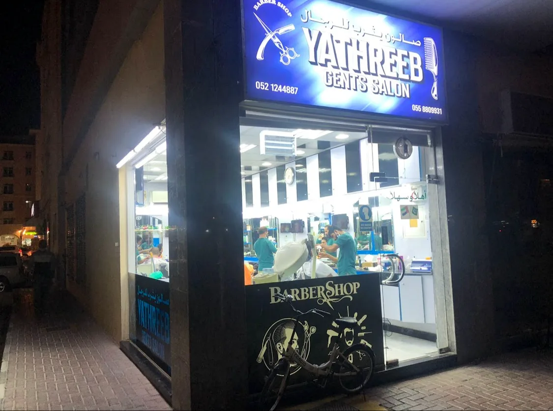Yathreeb Gents Salon storefront at night, with its glowing blue sign on 44A Street, Hor Al Anz, Deira