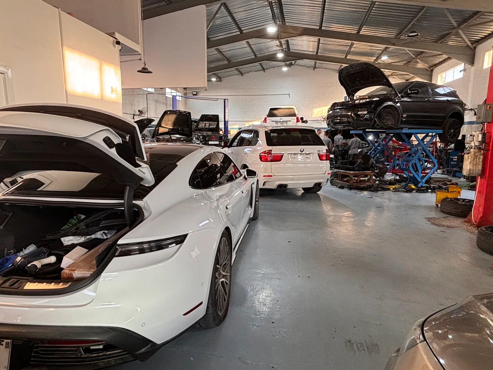 Auto Craft Garage workshop with a Porsche, BMW and Range Rover being serviced across multiple bays