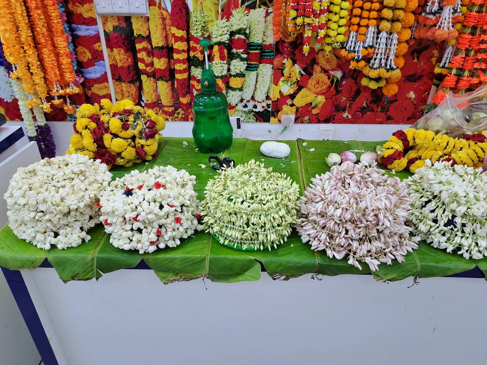 Strung jasmine and malli flowers laid on banana leaves