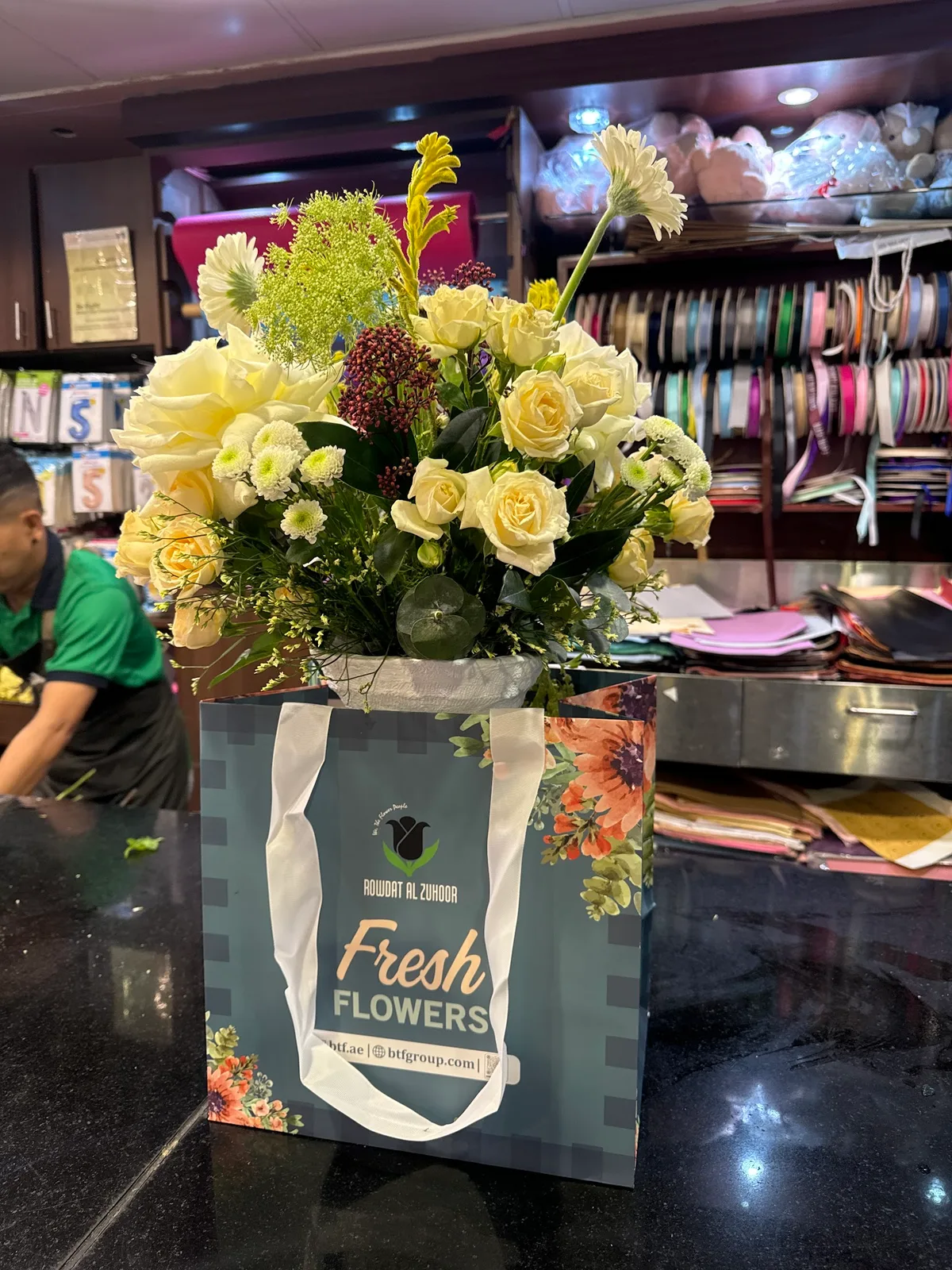 Cream and yellow rose arrangement in a Rowdat Al Zuhoor fresh flowers gift bag