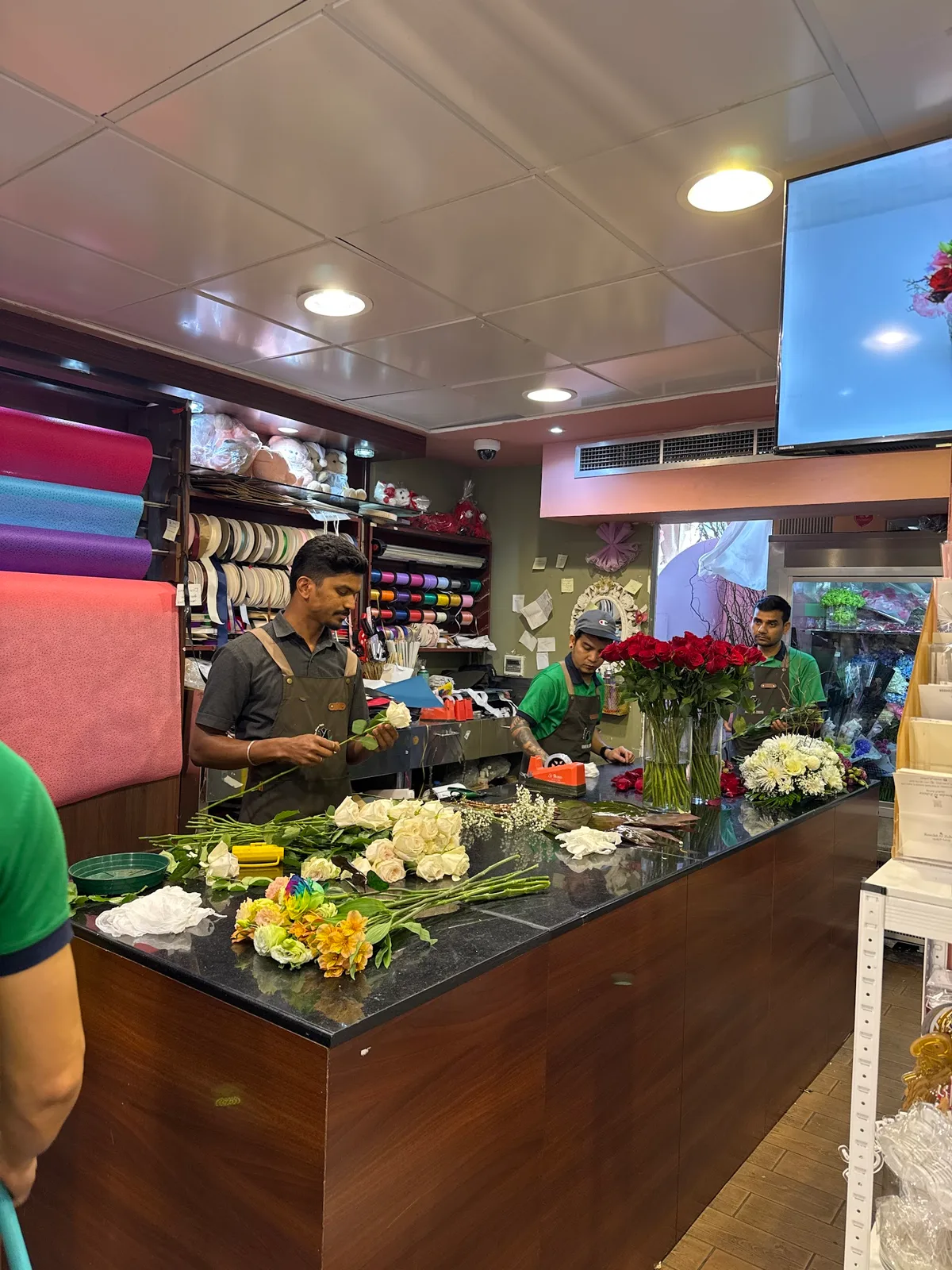 Florists arranging fresh roses at the counter