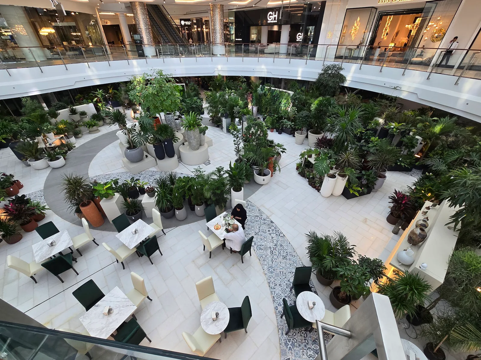 The Folivana garden seating area surrounded by potted plants beneath the mall atrium