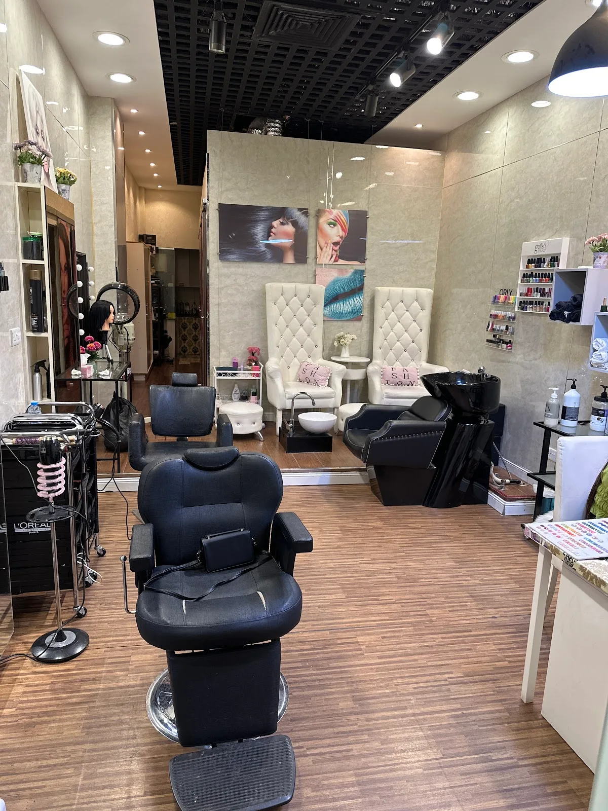 The styling area at The Style Hub with black chairs, warm lighting and a peach feature wall