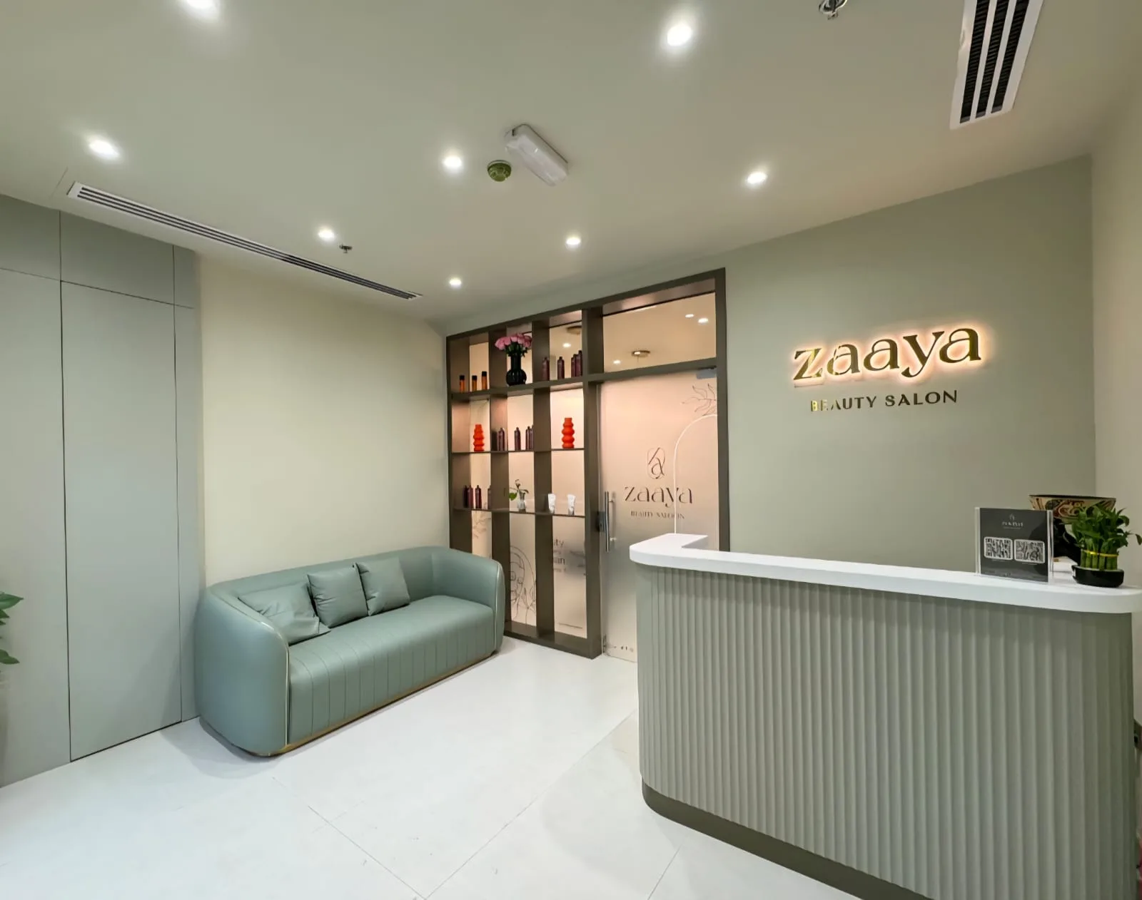 Zaaya Beauty Salon reception with gold wordmark sign and sage sofa