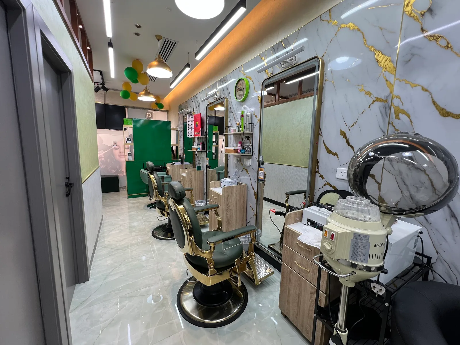 Interior of Haya Beauty Lounge with emerald-and-gold styling chairs and marble walls in Al Nahda 2, Dubai