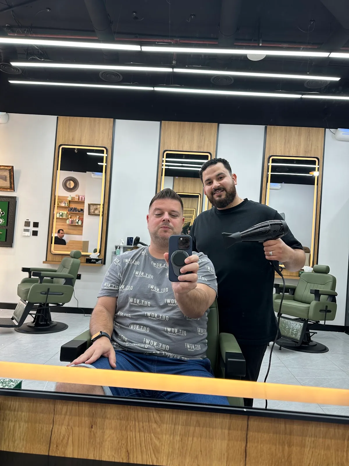 A BOYKA barber styling a happy client