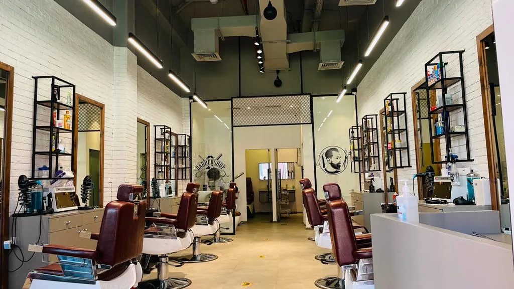 Wide view of the H&B Gents Salon interior with classic barber chairs and white-brick walls