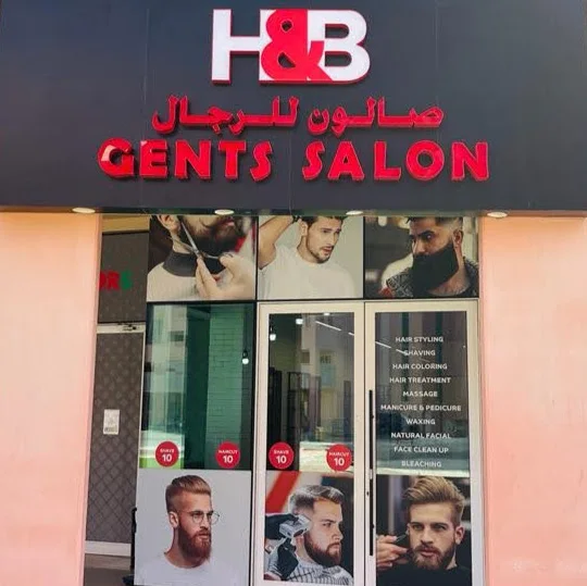 H&B Gents Salon storefront with the red H&B sign and service list, Discovery Gardens, Dubai