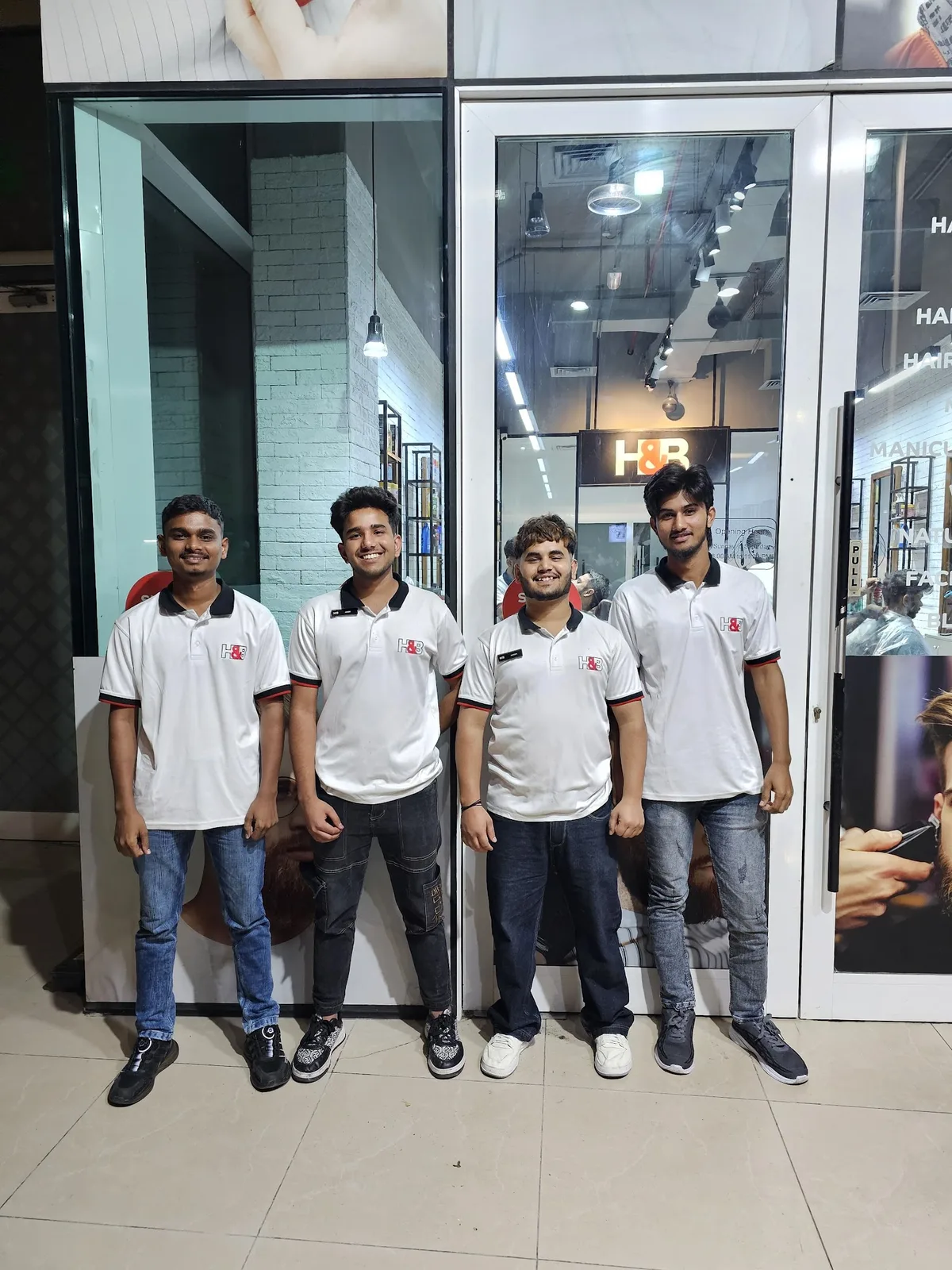 The H&B Gents Salon barber team in branded polos at the salon entrance