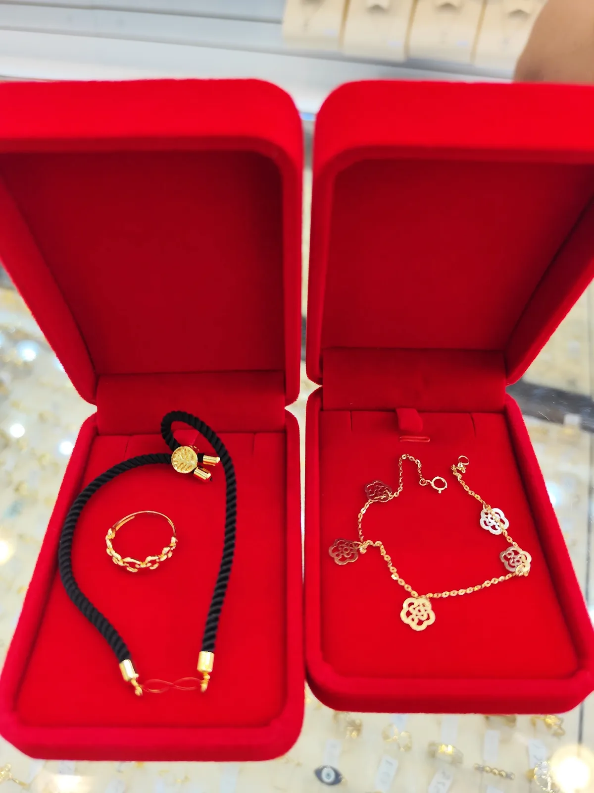Gold bracelet and floral necklace presented in red velvet boxes