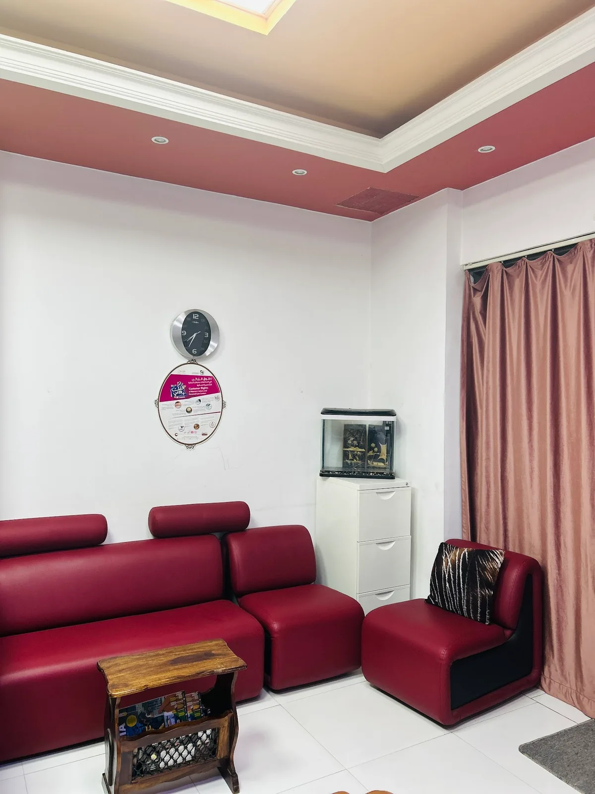 The ladies-only waiting lounge at Bold & Beautiful with red sofas and a calm interior
