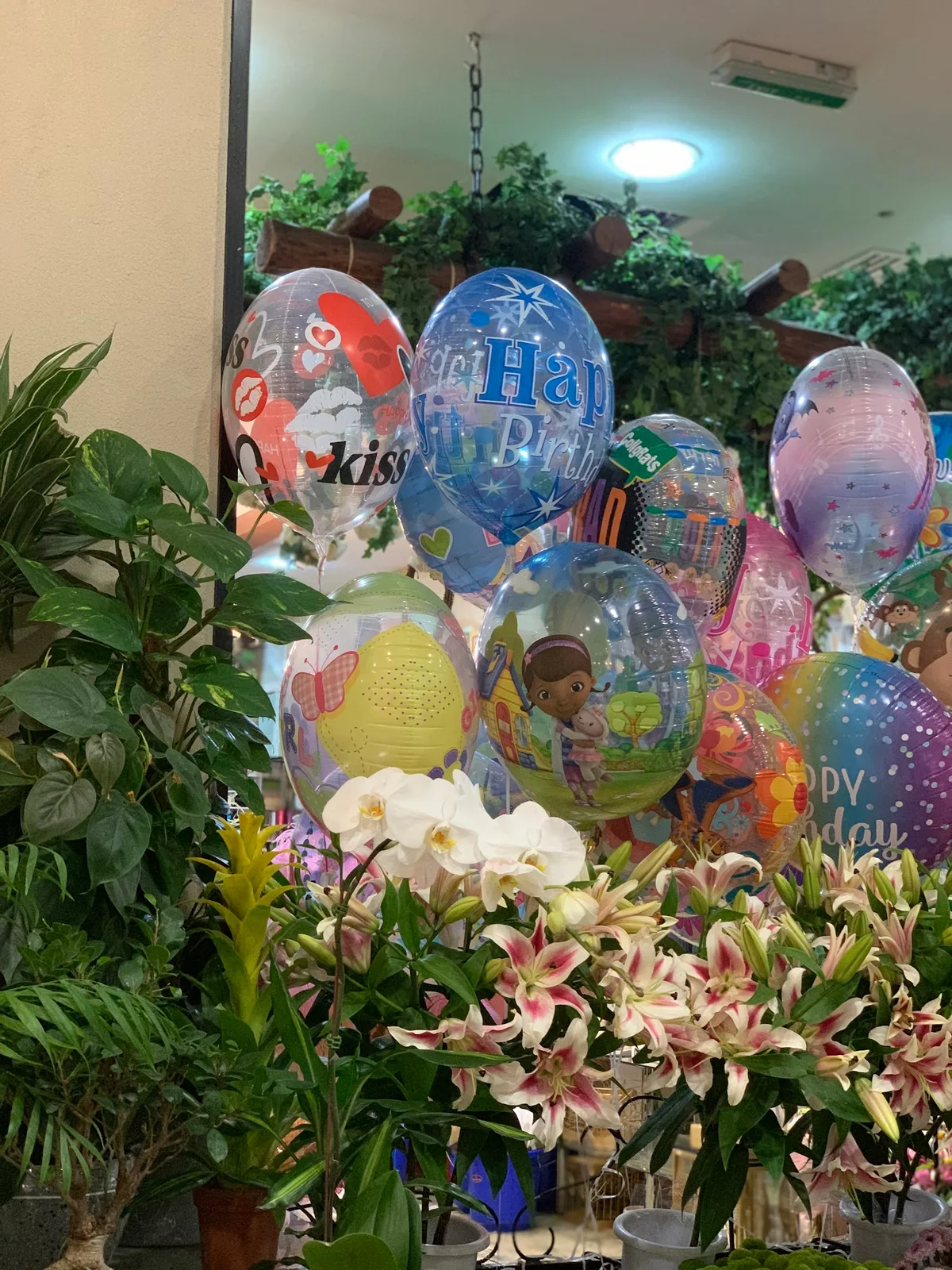 Foil balloons among lilies and orchids inside the shop