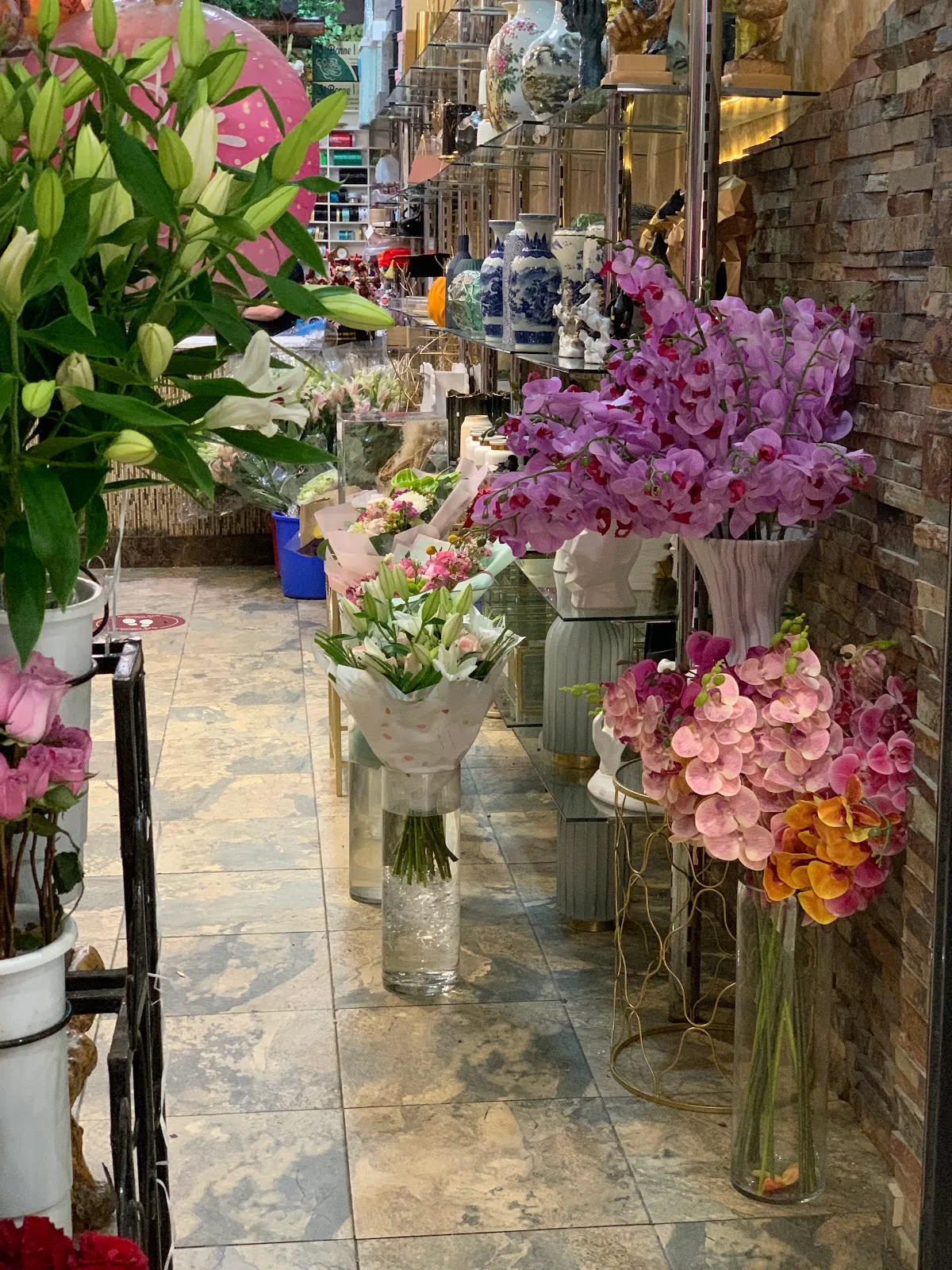 Bouquets and orchids arranged in glass vases along the shop aisle