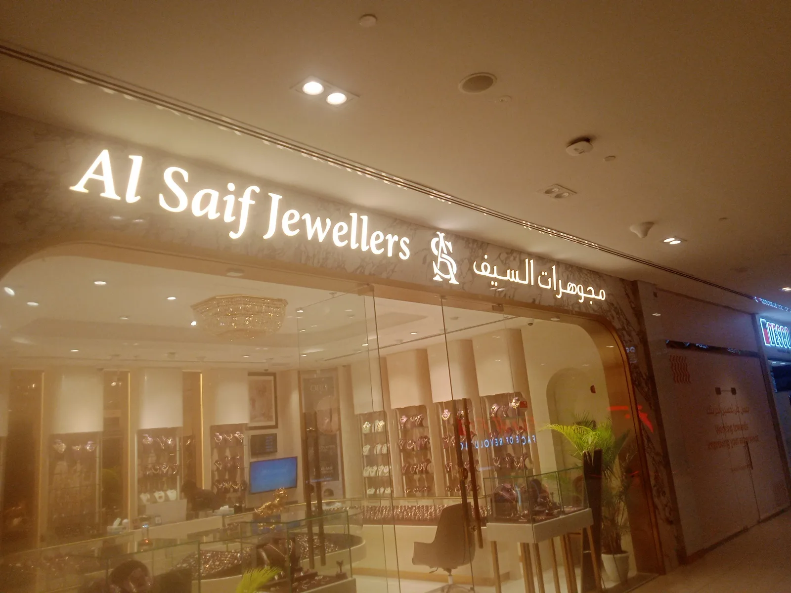 Warmly lit Al Saif Jewellers showroom signage and gold display cases inside the mall