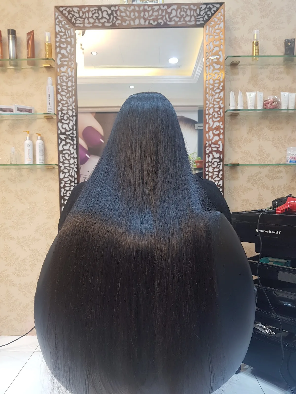 Long, glossy straightened hair styled at the salon