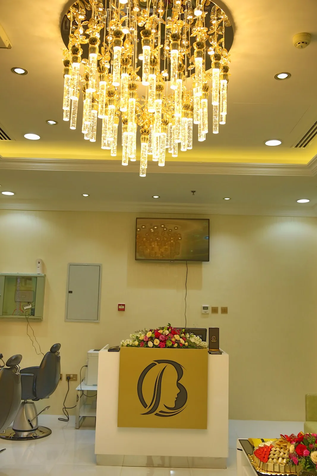Belle Avenue reception desk with the salon's B monogram beneath a crystal chandelier