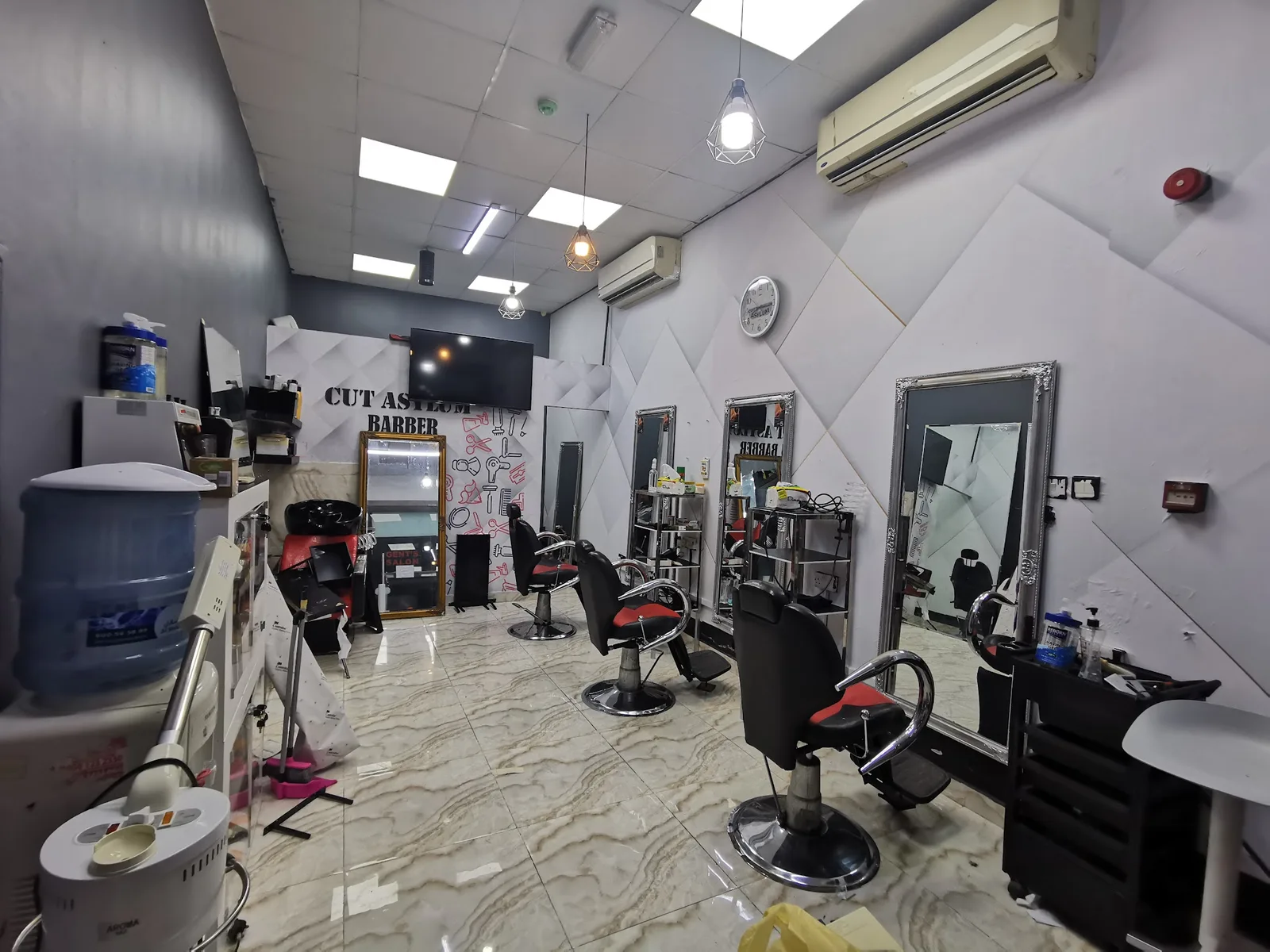 The Cut Asylum Barber wall and styling stations inside the Al Satwa shop