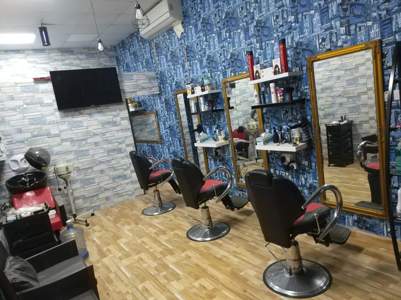 Inside Cuts Asylum barbershop — barber chairs, mirrors and the signature blue wall in Al Satwa, Dubai