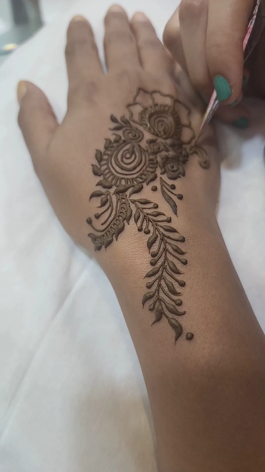 Detailed floral henna (mehndi) applied to the hand at Ayzel