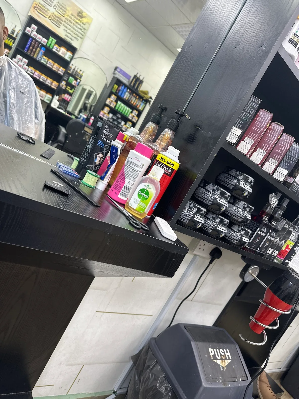 Grooming products and aftershave arranged on the counter and shelves at Blue Paradise Gents Saloon