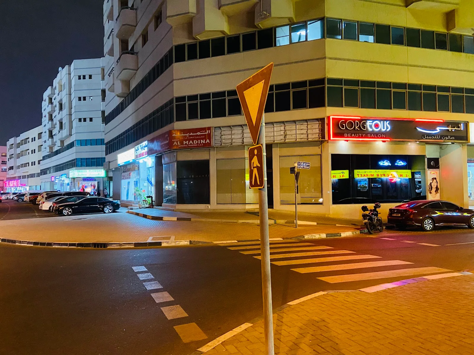 Gorgeous Beauty Saloon glowing neon sign and window display seen from the road junction at night