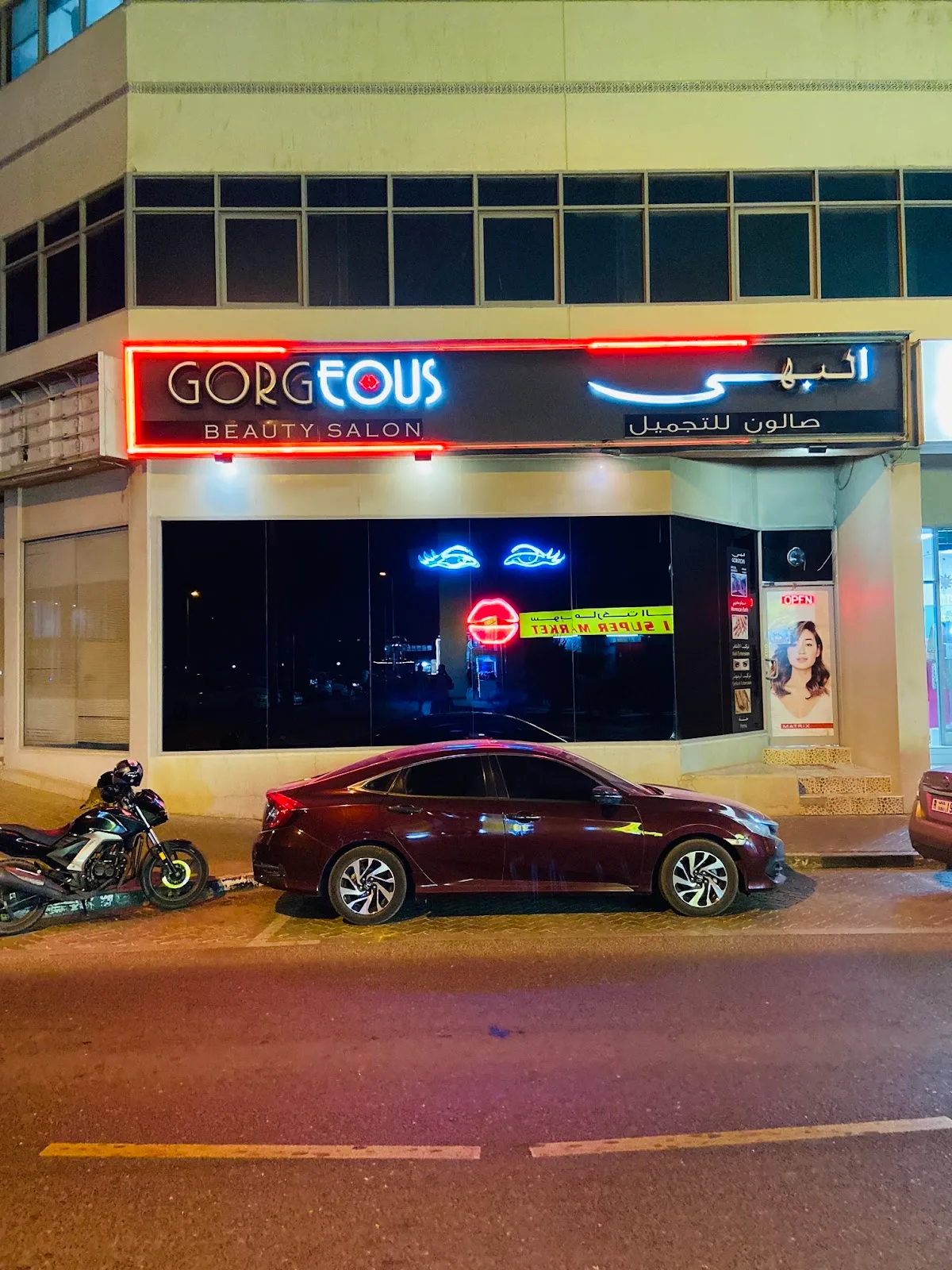 Gorgeous Beauty Saloon storefront at night, with its signature neon eyes and lips glowing in the window in Hor Al Anz, Deira