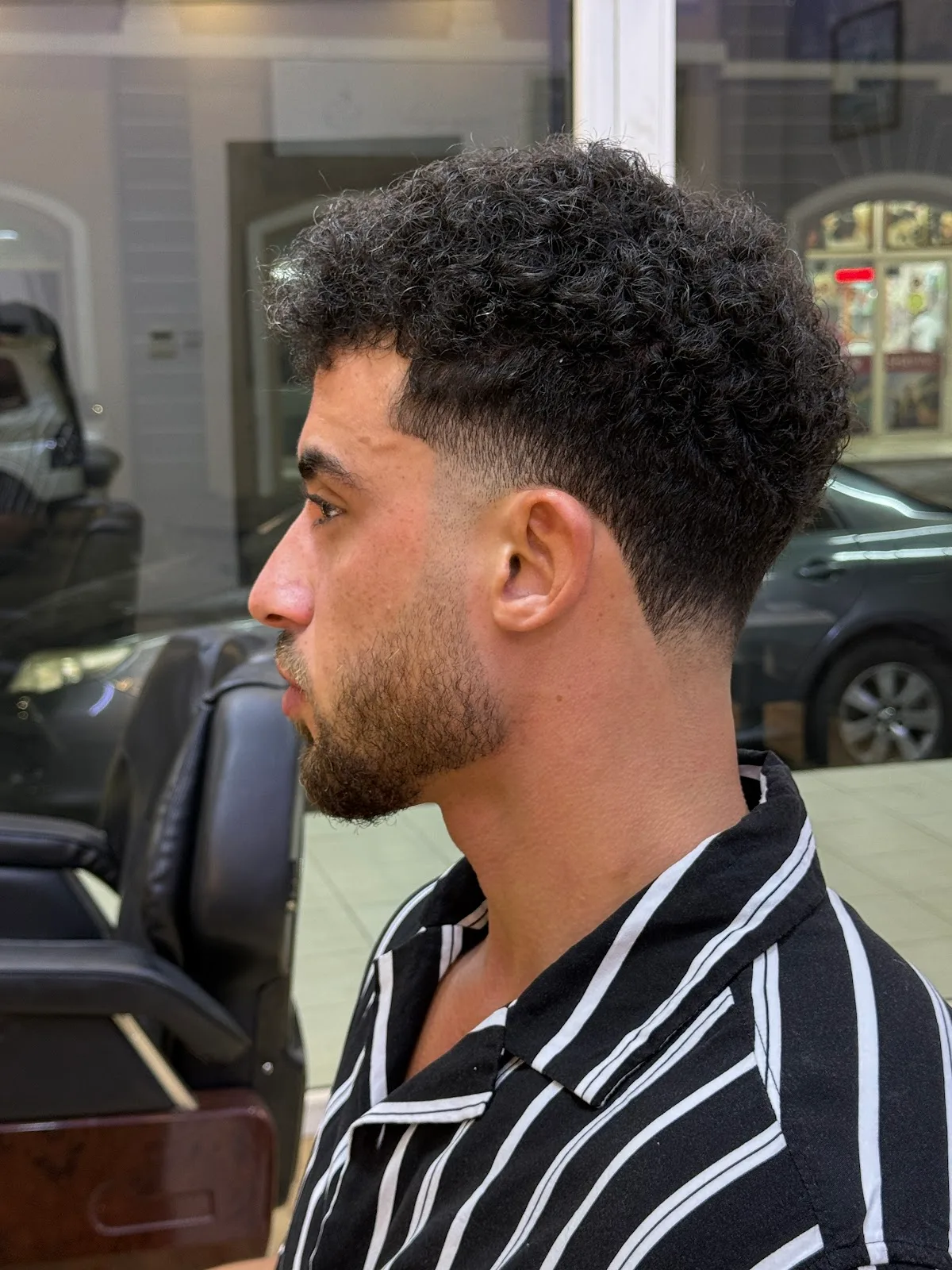 Curly top with low taper and beard line-up