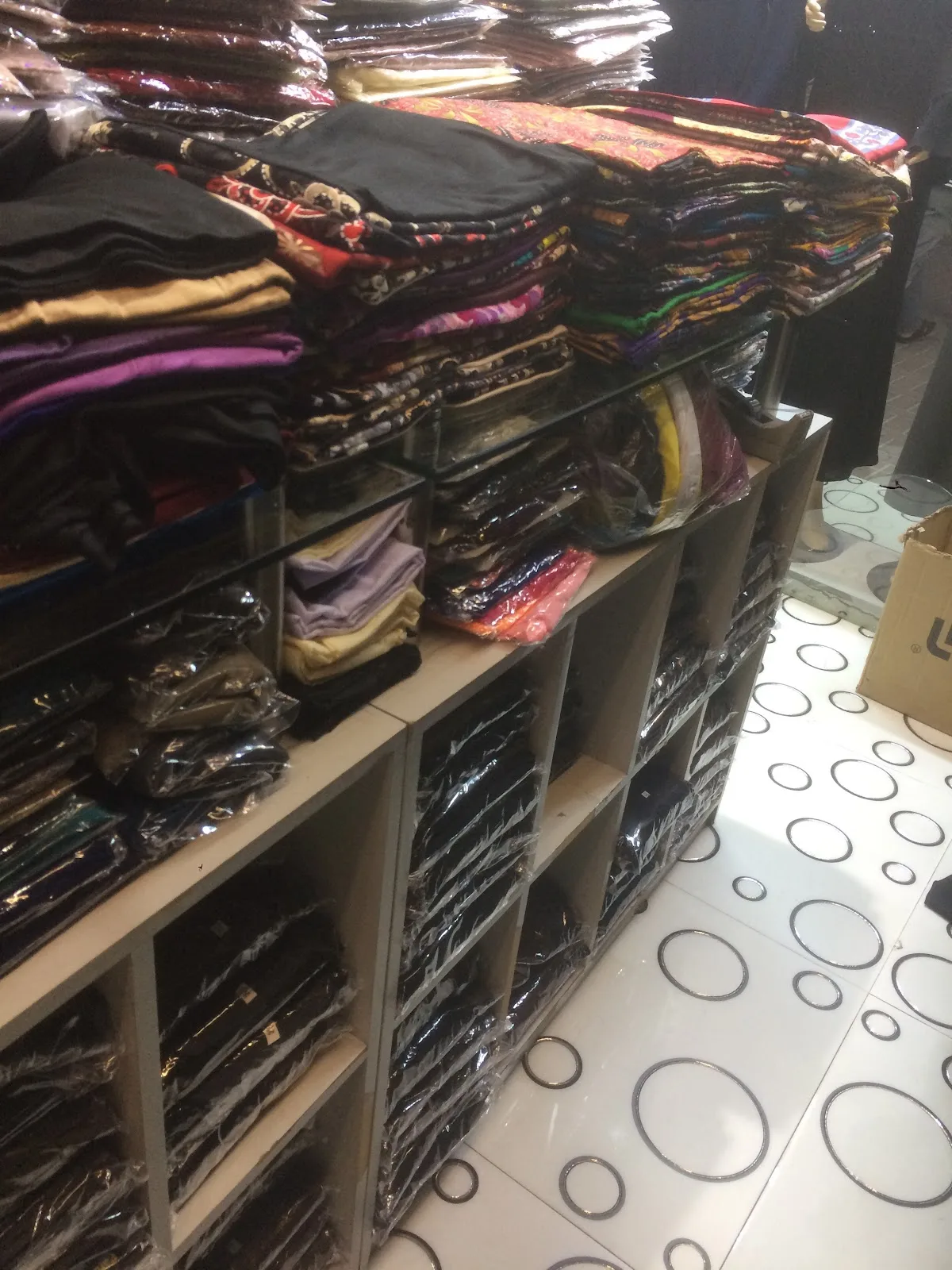 Shelves of folded fabrics and scarves stacked at Parda Palace